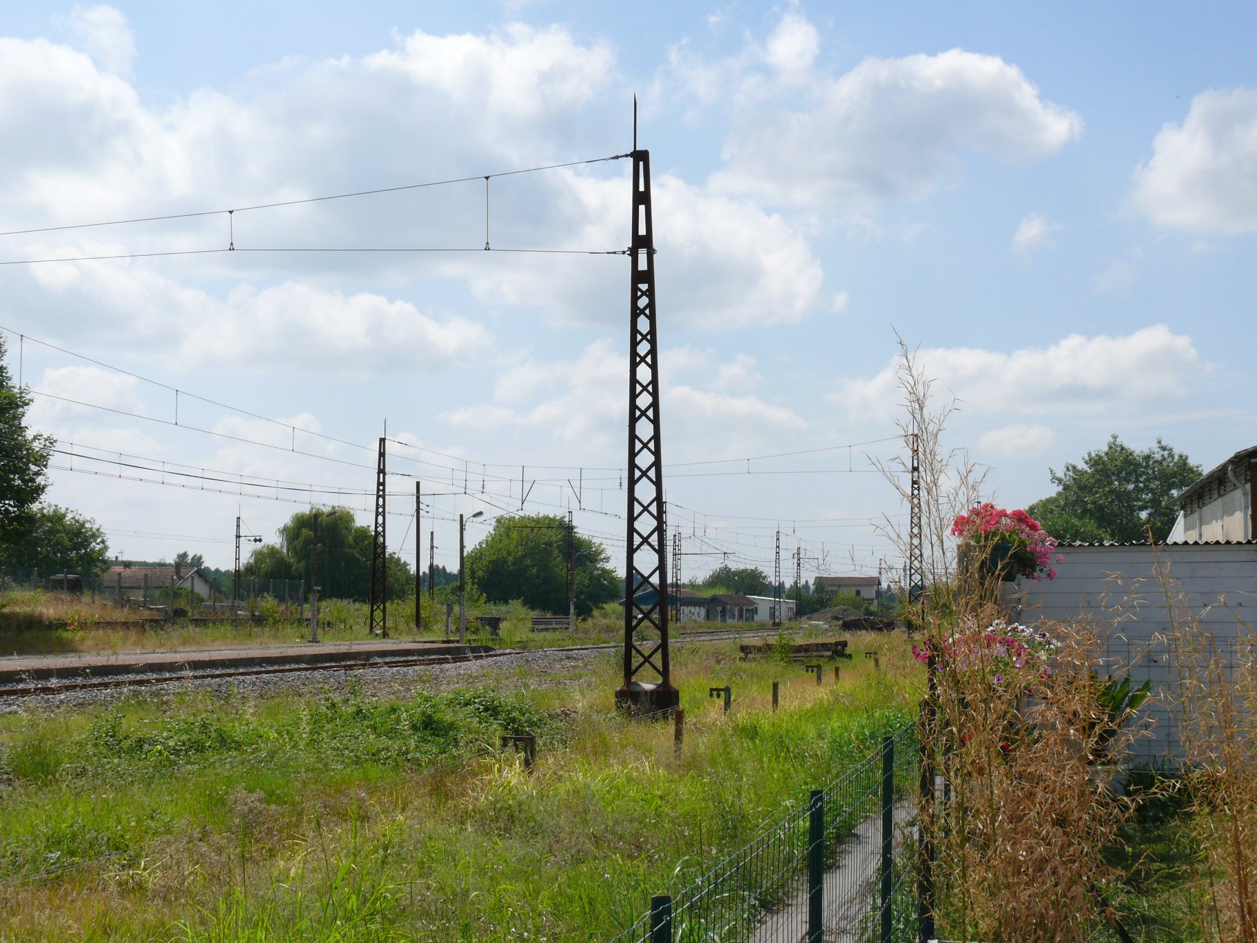 Équipe de maintenance sur une voie métrique près d'une gare cambodgienne