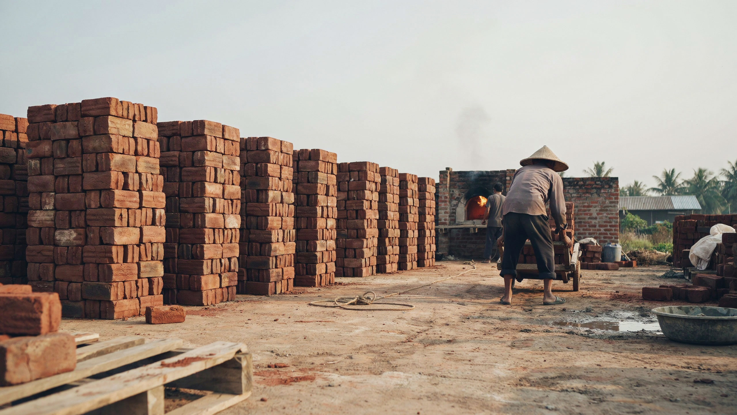 Briques empilées sur une aire de fabrication au Cambodge