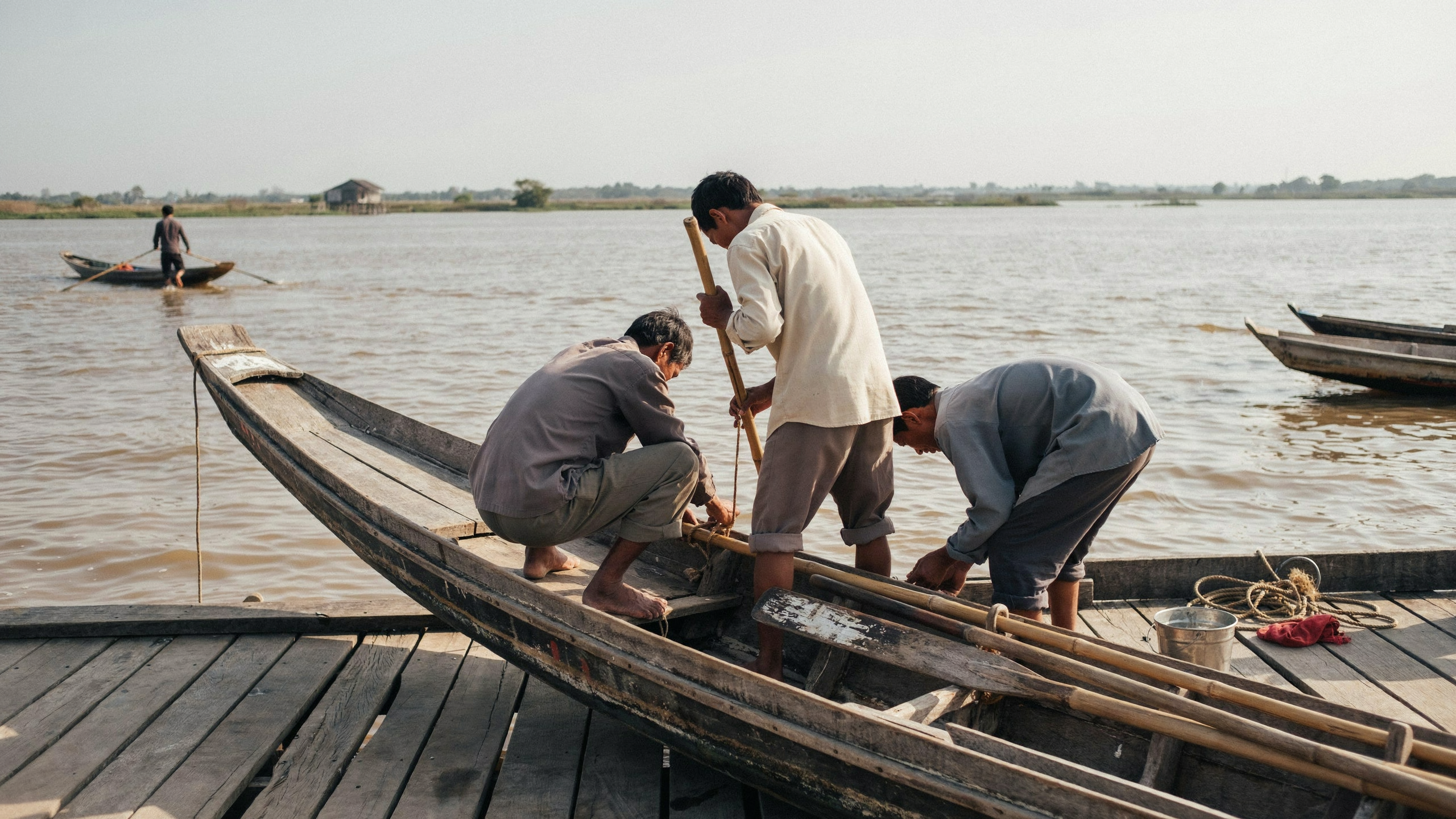 Illustration documentaire sur rameurs cambodgiens préparant une pirogue traditionnelle
